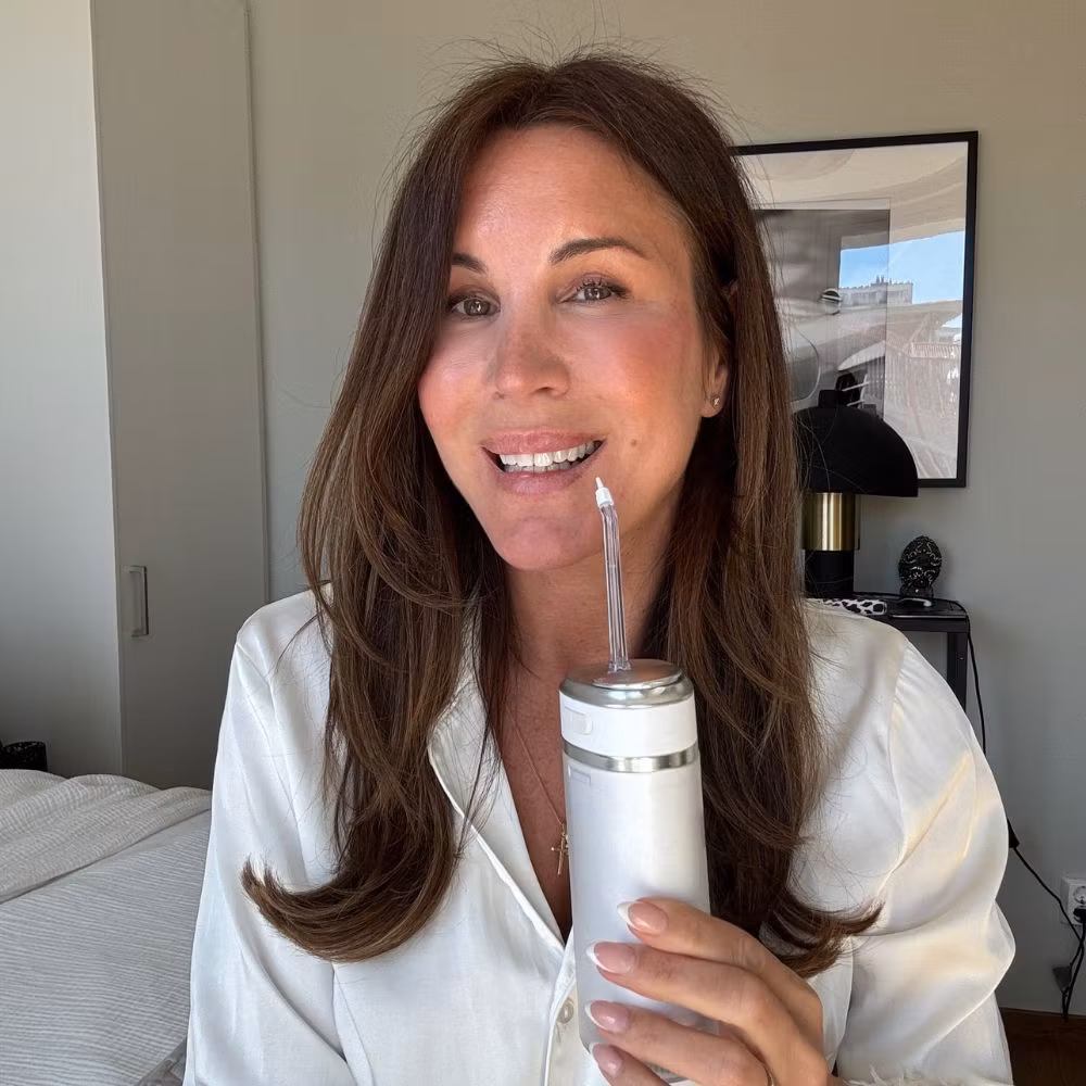 En kvinne holder Water Flosser Pro hjemme